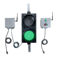 Traffic light system with green LED light, connected receiver and switch box transmitter on a white background.