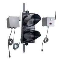 Angled perspective of a wireless traffic light system with  LED lights off and accompanying control box transmitter with mirrored pilot light and 2-position switch ton a white background.