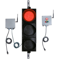 Front perspective of a wireless traffic light system with red LED light on and accompanying control box transmitter with mirrored pilot light and 3-position switch ton a white background.